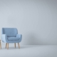 en minimalistisch ingerichte ruimte met een lichtblauwe fauteuil, een bijzettafeltje en een gele staande lamp, geplaatst op een strakke, lichtgrijze PVC vloer. De vloer draagt bij aan de moderne en strakke uitstraling van het interieur.
