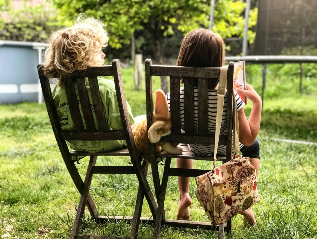 twee kinderen zitten in de tuin