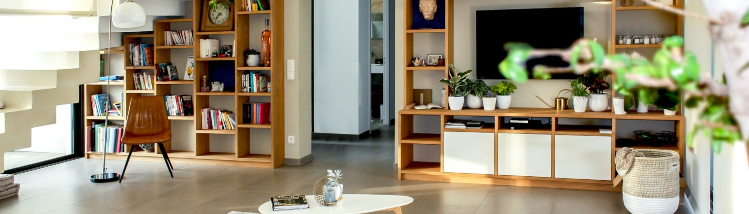 Woonkamer met duurzaam interieur, inclusief houten boekenplanken, veel groen en een moderne trap